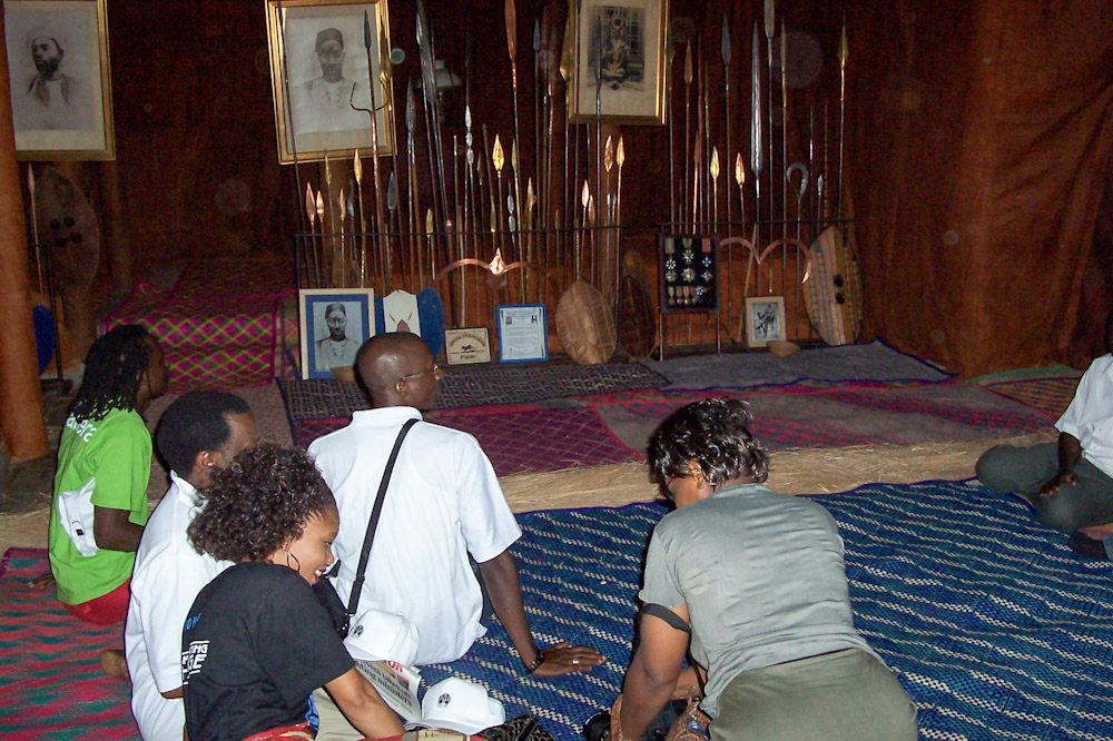 Listening to our guide in King Mwanga's Palace in Uganda