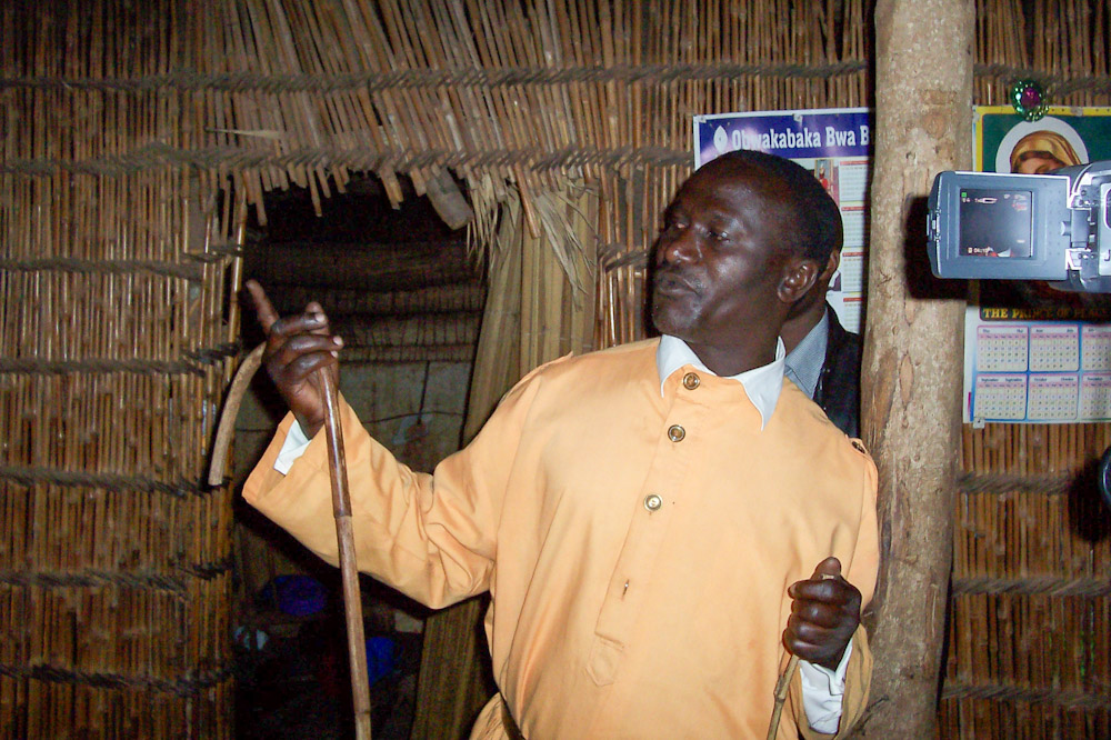 Listening to our guide in King Mwanga's Palace in Uganda